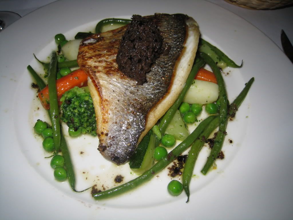 Sea bream on a bed of spring vegetables with olive tapenade