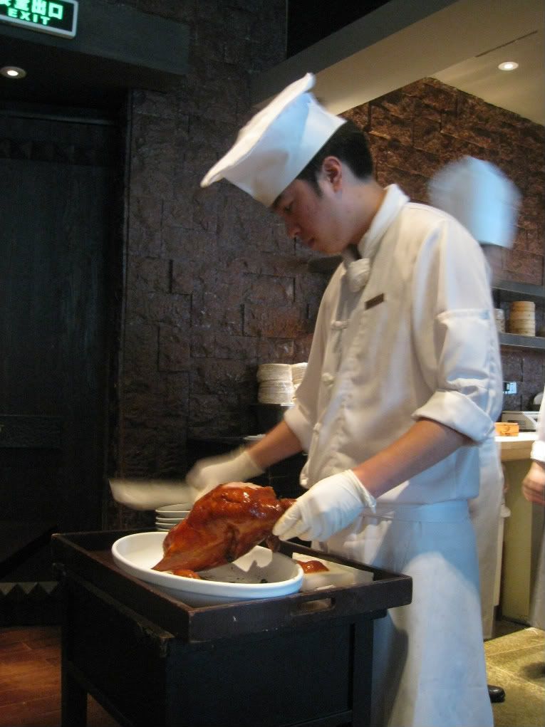 Xindalu server cutting Peking duck at tableside