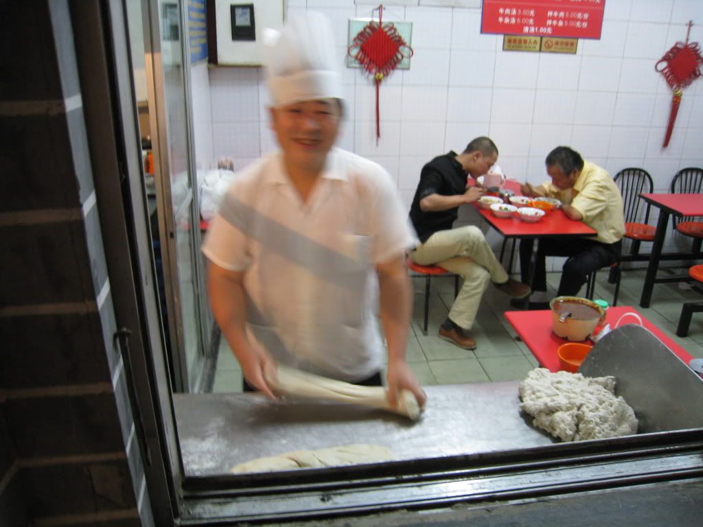 Window front with the guy starting to pull the dough for the noodles